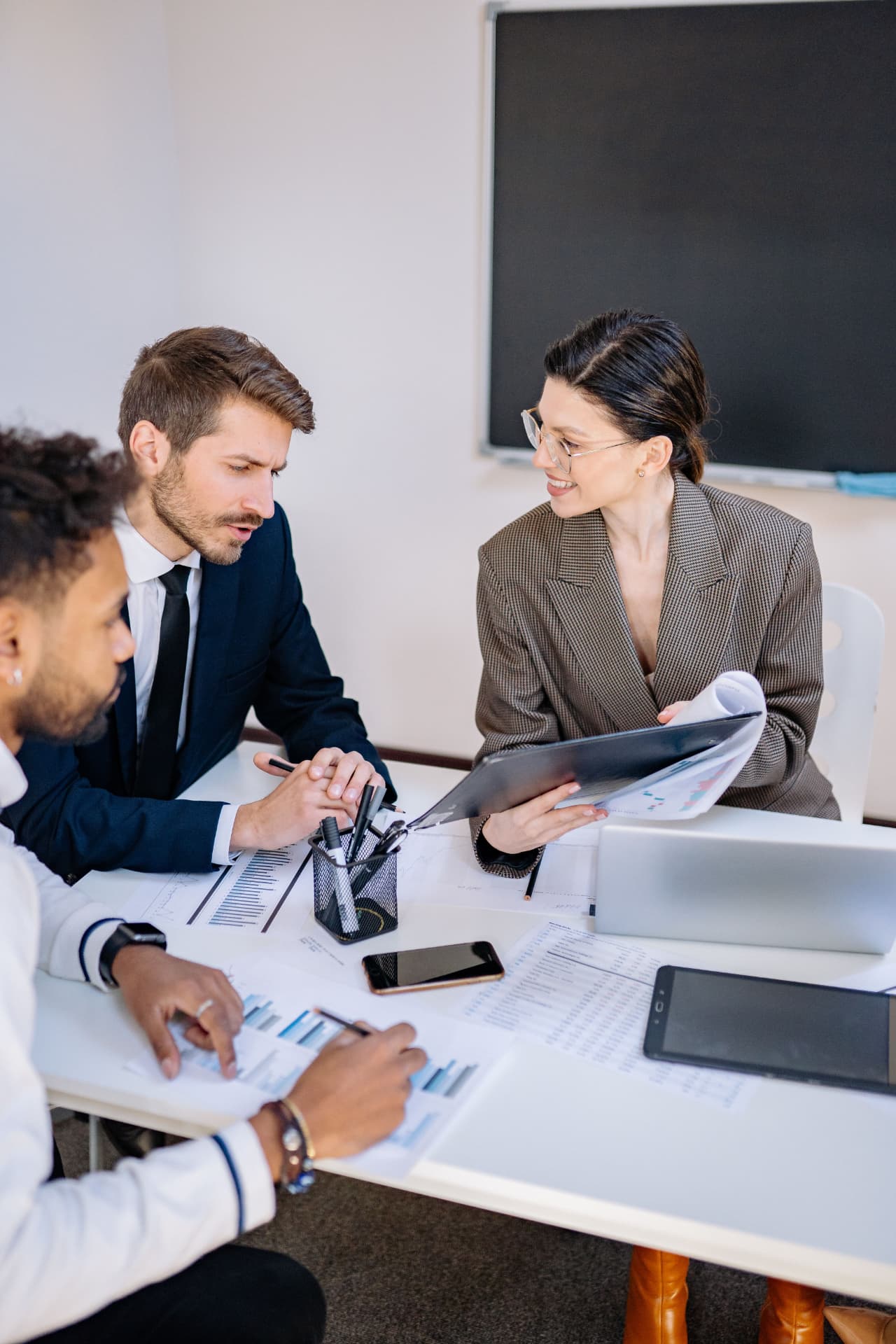 Profesionales en una reunión de trabajo analizando documentos